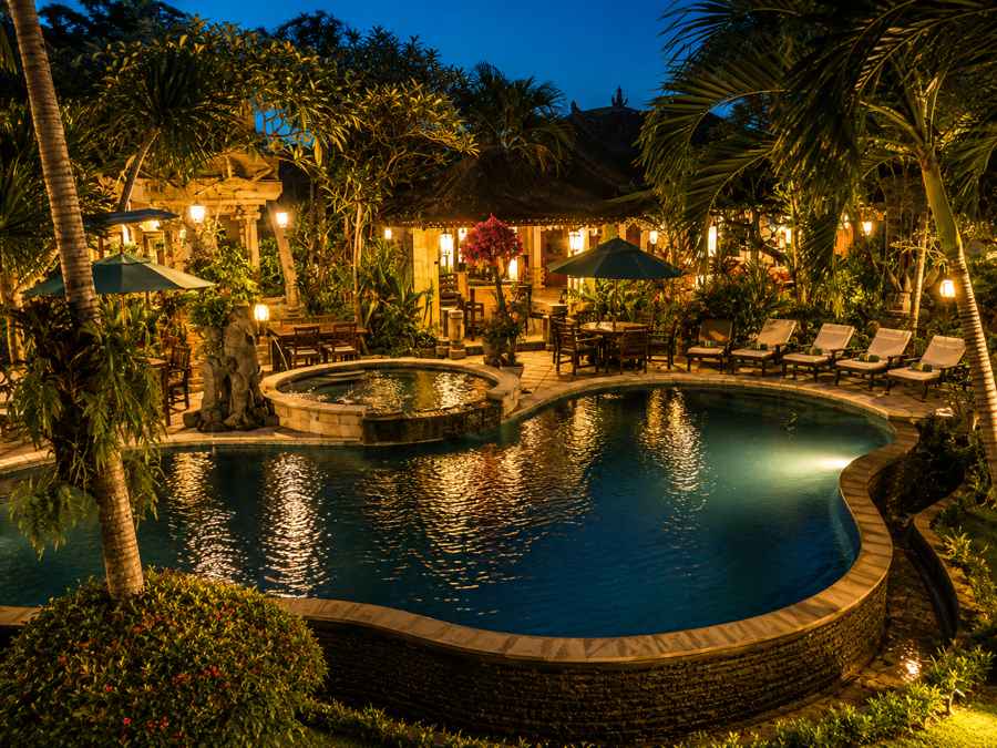 Outdoor pool with loungers and tropical planting